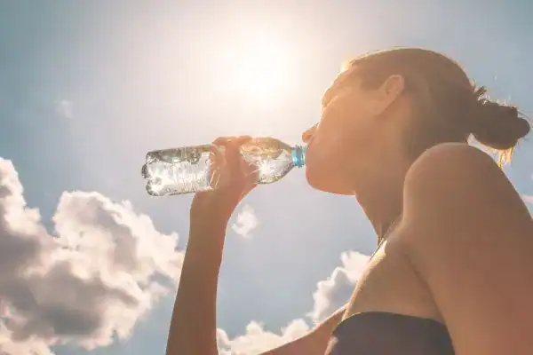 Hydration: The Secret Ingredient for a Toned Stomach and Enhanced Fitness 3 Image of woman drinking water to hydrate Broxburn after run.
